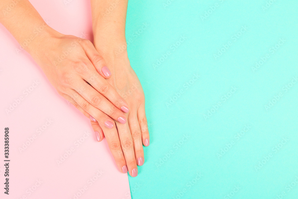 female  manicure. Beautiful young woman's hands on pastel   background - Image
