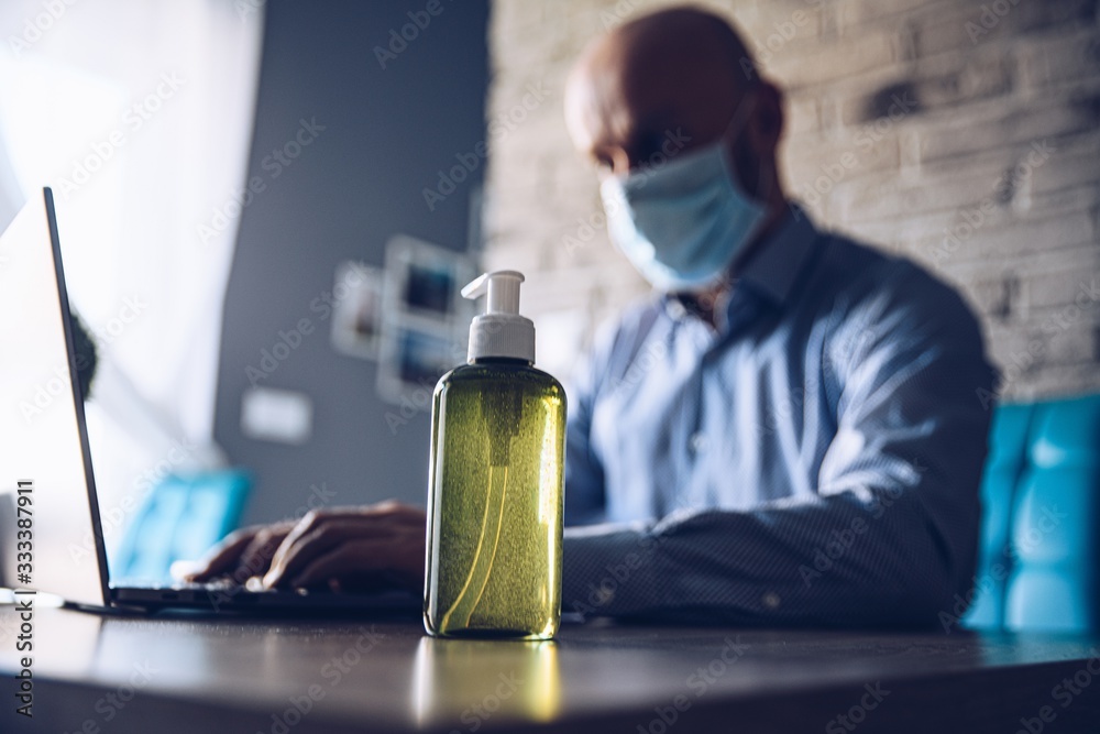 Man working at home and disinfect hand with antibacterial gel. Man working at home and disinfect hand with antibacterial gel.