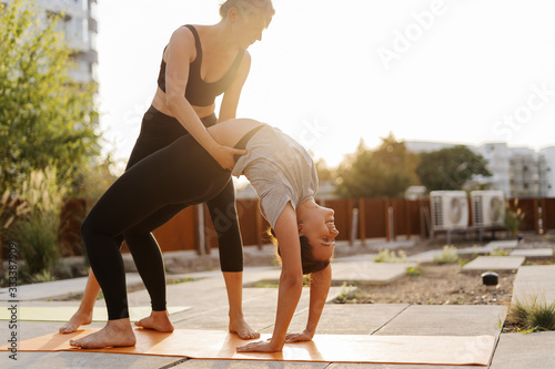 Two young girls practicing stretching and yoga workout exercise together