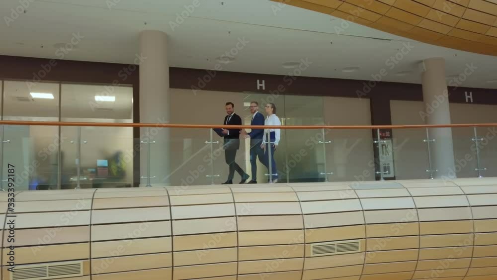 Business people talking and discussing work in building hallway Business people talking and discussing work in building hallway