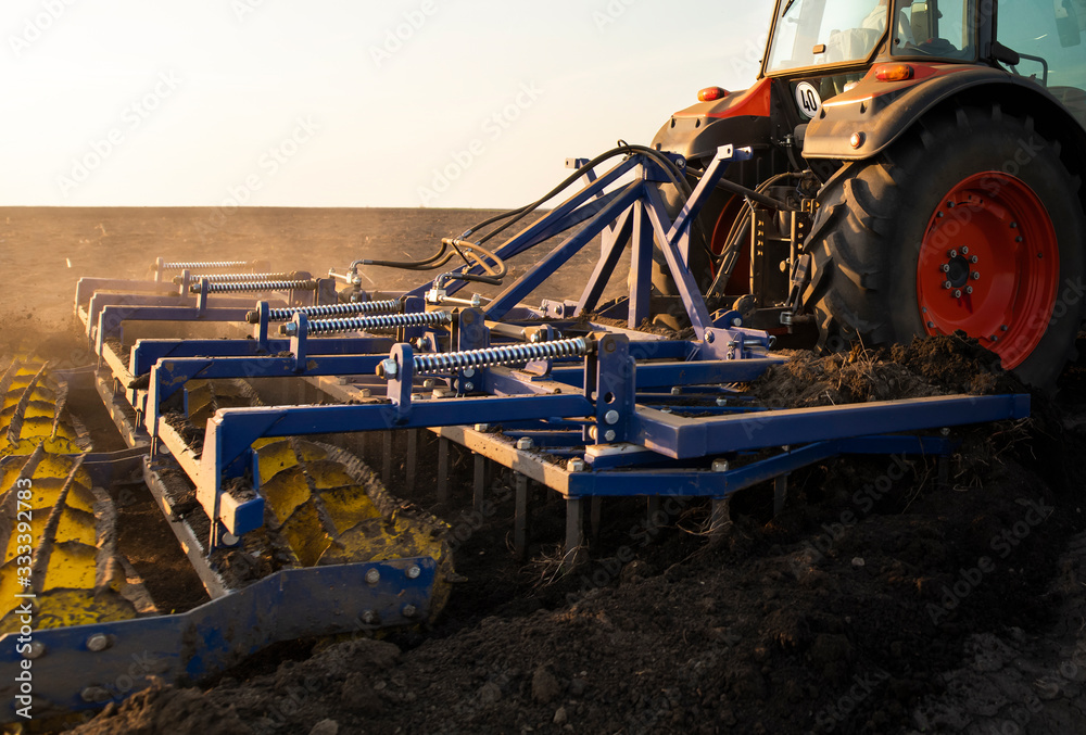 Tractor is preparing the land at dusk