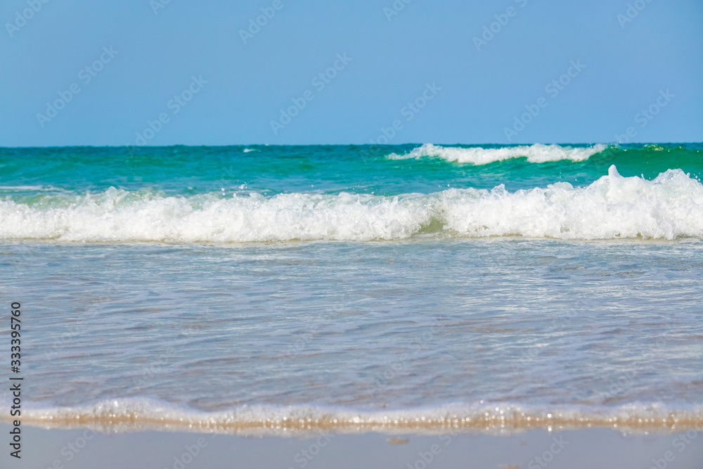 Ocean waves on the sandy beach for background, concept of the beach in the summer Ocean waves on the sandy beach for background, concept of the beach in the summer