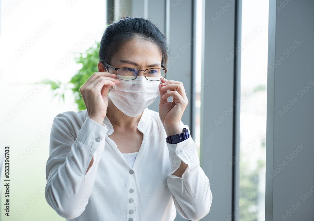 Asian business woman wearing virus protective mask in office.To prevent PM 2.5 air pollution,prevent germs protect from coronavirus or covid-19 virus world pandemic,health care and medicine concept Asian business woman wearing virus protective mask in office.To prevent PM 2.5 air pollution,prevent germs protect from coronavirus or covid-19 virus world pandemic,health care and medicine concept