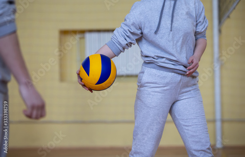 Man's hands hold a volleyball.Volleyball in the gym.