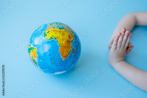 Children s hands pray for planet Earth. Concept of global problems of humanity.