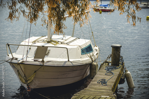 Barca ancorata nel porto del lago di Viverone con porticciolo e passerella da campeggio photo