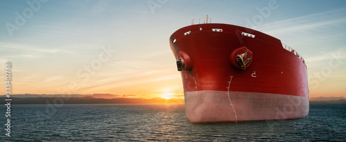 Fotografie, Obraz Close up of large red merchant crago ship in the ocean underway