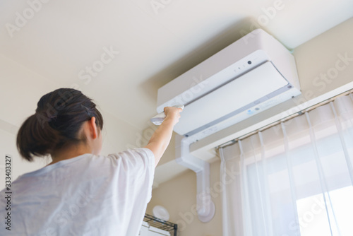 Woman control air conditioner power on in Japanese living room