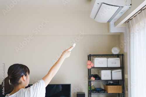 Woman control air conditioner power on in Japanese living room