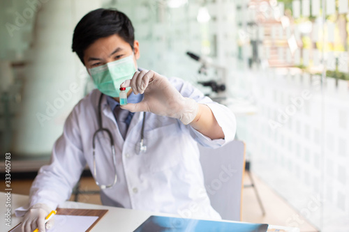 Doctors are searching for Covid's anti-virus serum by studying lung infection photos, protected by a mask and sanitary gloves.