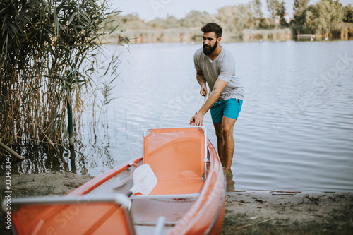 Young man pulling canoe int...