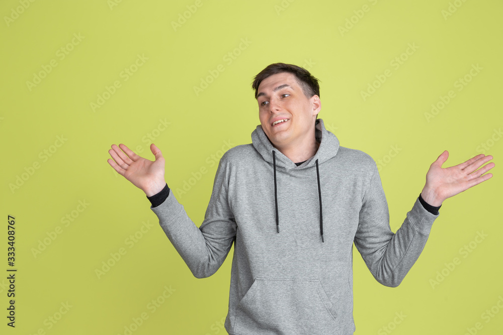 Doesn't know, uncertain. Caucasian man's portrait isolated on yellow studio background. Freaky male model in casual clothes. Concept of human emotions, facial expression, sales, ad. Unusual appearance Doesn't know, uncertain. Caucasian man's portrait isolated on yellow studio background. Freaky male model in casual clothes. Concept of human emotions, facial expression, sales, ad. Unusual appearance