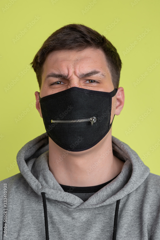 Hard thinking. Caucasian man's portrait isolated on yellow studio background. Freaky model in black face mask. Concept of human emotions, facial expression, sales, ad. Unusual appearance. Hard thinking. Caucasian man's portrait isolated on yellow studio background. Freaky model in black face mask. Concept of human emotions, facial expression, sales, ad. Unusual appearance.