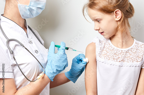 Doctor pediatric holds an injection vaccination the girl