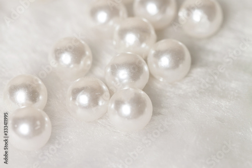 Bunch round white shiny pearls with soft fur background
