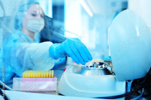 a female scientist in a protective medical mask and rubber gloves makes PCR DNA tests in a modern chemical and bacteriological laboratory.2019-nCoV  coronavirus  China 