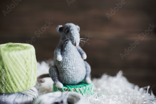 Fototapeta Naklejka Na Ścianę i Meble -  Handmade knitted toy. Amigurumi gray rat toy and on the wooden background . Crochet stuffed animals.