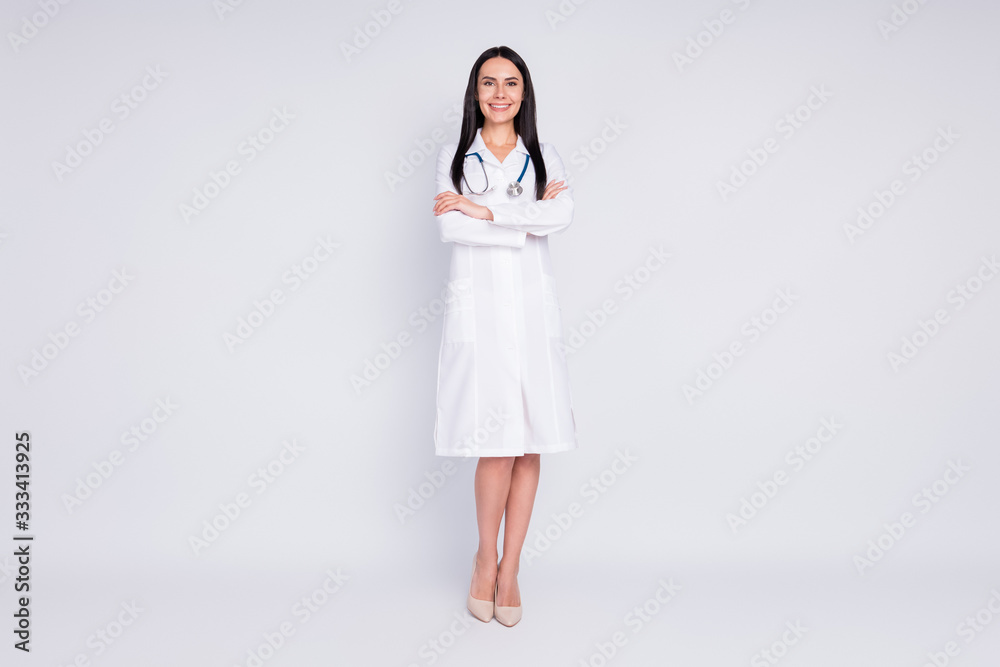 Full size photo of beautiful cheerful professional lady good mood smiling patient arms crossed wear long white lab coat stethoscope high-heels isolated grey color background Full size photo of beautiful cheerful professional lady good mood smiling patient arms crossed wear long white lab coat stethoscope high-heels isolated grey color background