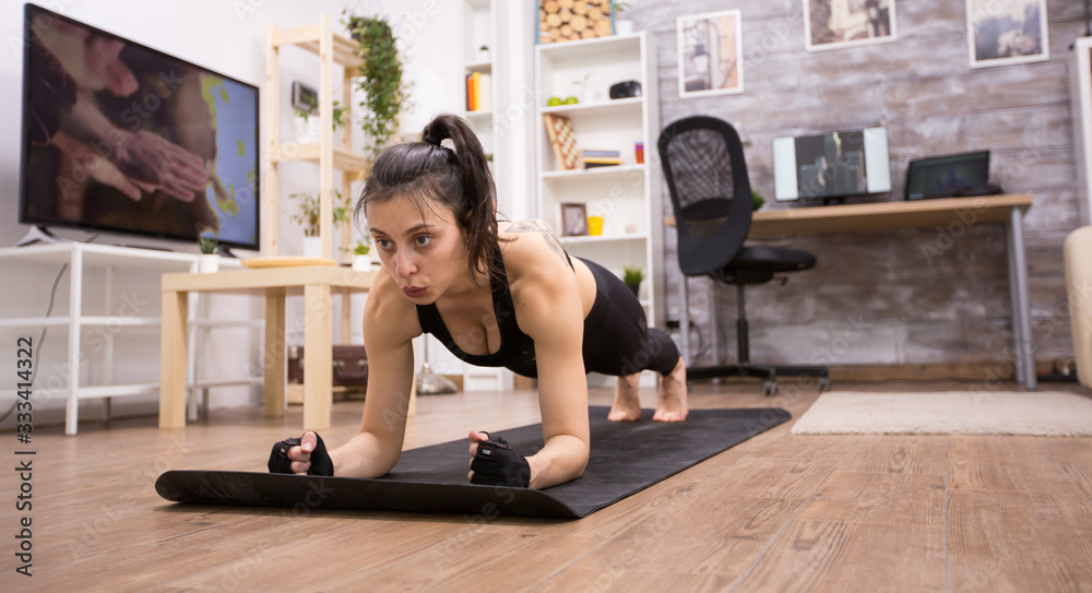 Adult woman doing plank exercise to improve her fitness Adult woman doing plank exercise to improve her fitness
