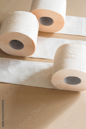 rolls of toilet paper peach beige color on beige background