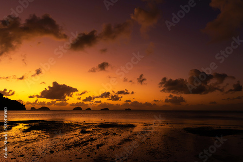 Sunset on the tropical beach. Orange sunset on the ocean. Colorful sunset in the tropics