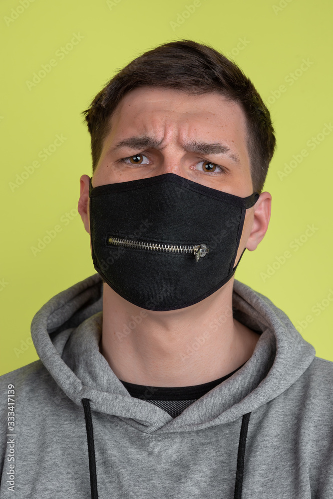 Asking. Close up caucasian man's portrait isolated on yellow studio background. Freaky male model in black face mask. Concept of human emotions, facial expression, sales, ad. Unusual appearance. Asking. Close up caucasian man's portrait isolated on yellow studio background. Freaky male model in black face mask. Concept of human emotions, facial expression, sales, ad. Unusual appearance.