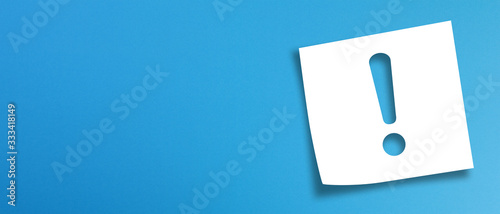 Note paper with exclamation mark on panoramic blue background 