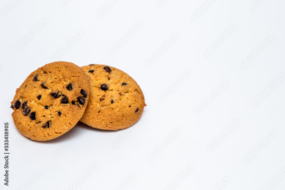 two homemade cookies with pieces of chocolate for breakfast lie on a white isolated background. two homemade cookies with pieces of chocolate for breakfast lie on a white isolated background.