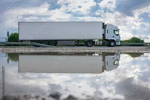 Truck with refrigerated semi-trailer for the transport of perishable food circulating on the highway photo