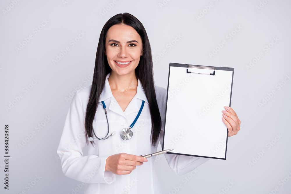 Photo of beautiful professional doc lady showing patient place for signing contract clinic insurance agreement wear stethoscope white lab coat isolated grey color background Photo of beautiful professional doc lady showing patient place for signing contract clinic insurance agreement wear stethoscope white lab coat isolated grey color background