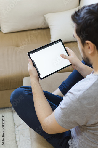 Male using stylus on tablet to draw his ideas at home photo