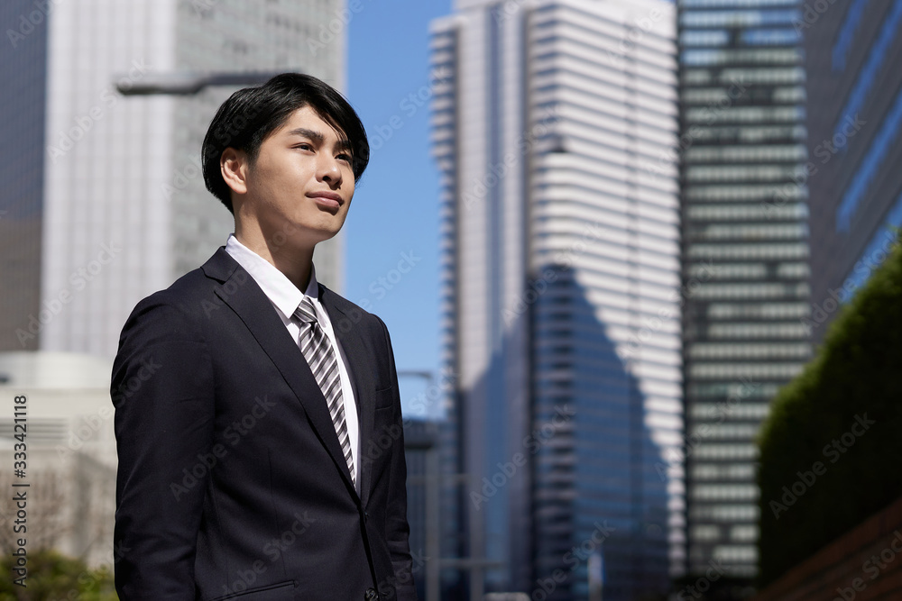 オフィス街で笑顔で立つ日本人男性ビジネスマン オフィス街で笑顔で立つ日本人男性ビジネスマン