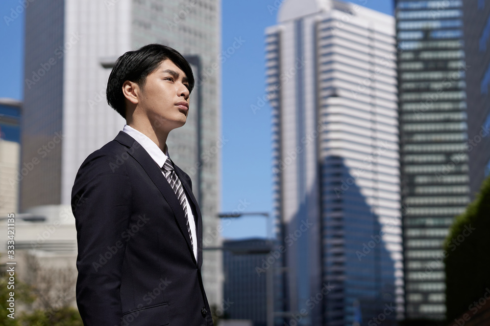 オフィス街で真剣な表情で立つ日本人男性ビジネスマン オフィス街で真剣な表情で立つ日本人男性ビジネスマン