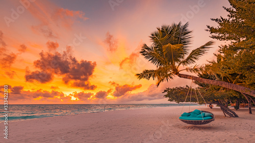 Tropical beach sunset as summer landscape with luxury resort beach swing or hammock and white sand and calm sea for sunset beach landscape. Tranquil beach scenery vacation and summer holiday concept. © icemanphotos