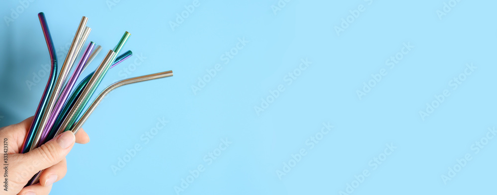 Φωτογραφία several reusable metal stainless steel drinking straws in female hand on a blue background