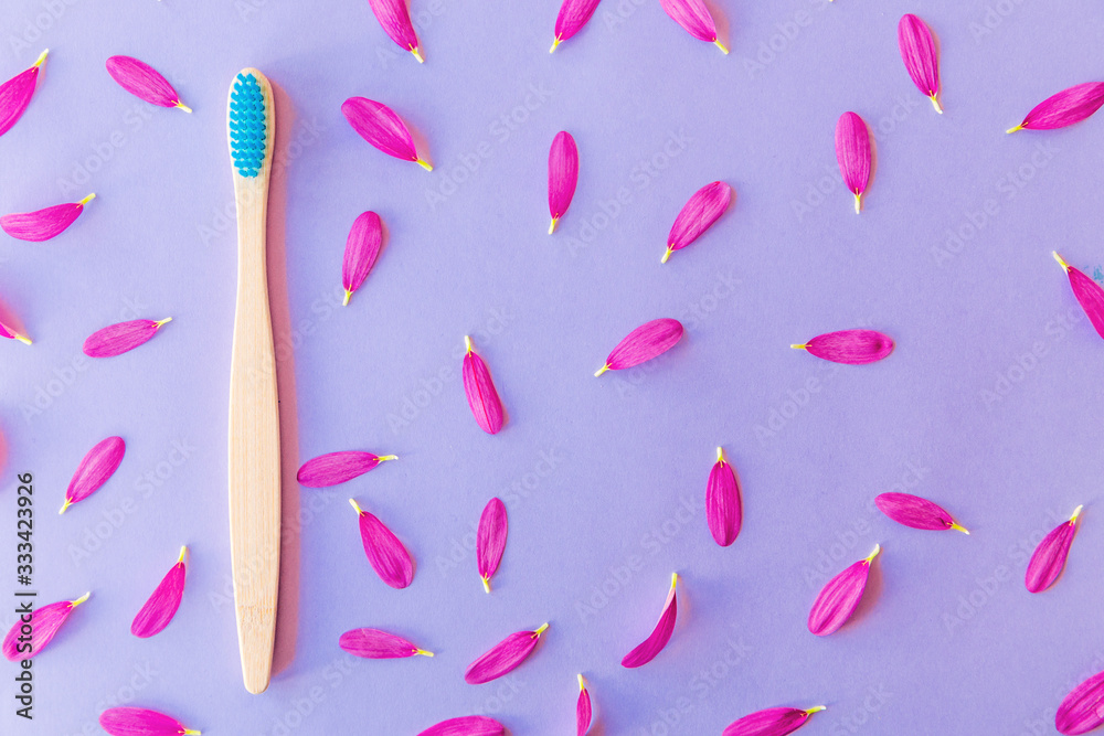 Blue wooden toothbrushes on violet or purple background with petals. Blue wooden toothbrushes on violet or purple background with petals.