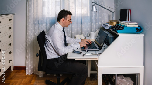 Man working from home with laptop wearing shirt and tie