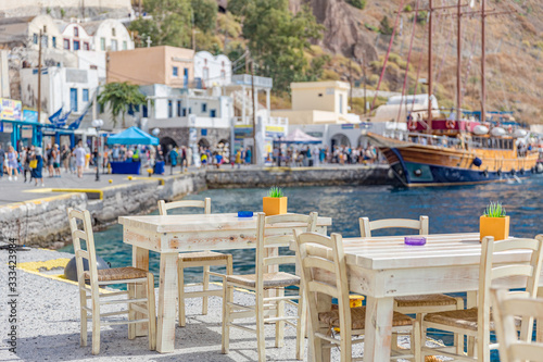 Cafe on the sea coast in the port of Santorini island, Greece.