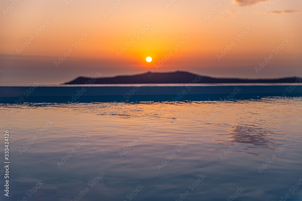 Amazing sunset relaxing mood the pool in a luxurious hotel resort at sunset enjoying perfect beach holiday vacation. Summer landscape, beautiful sunset sky, banner concept of Santorini vacation
