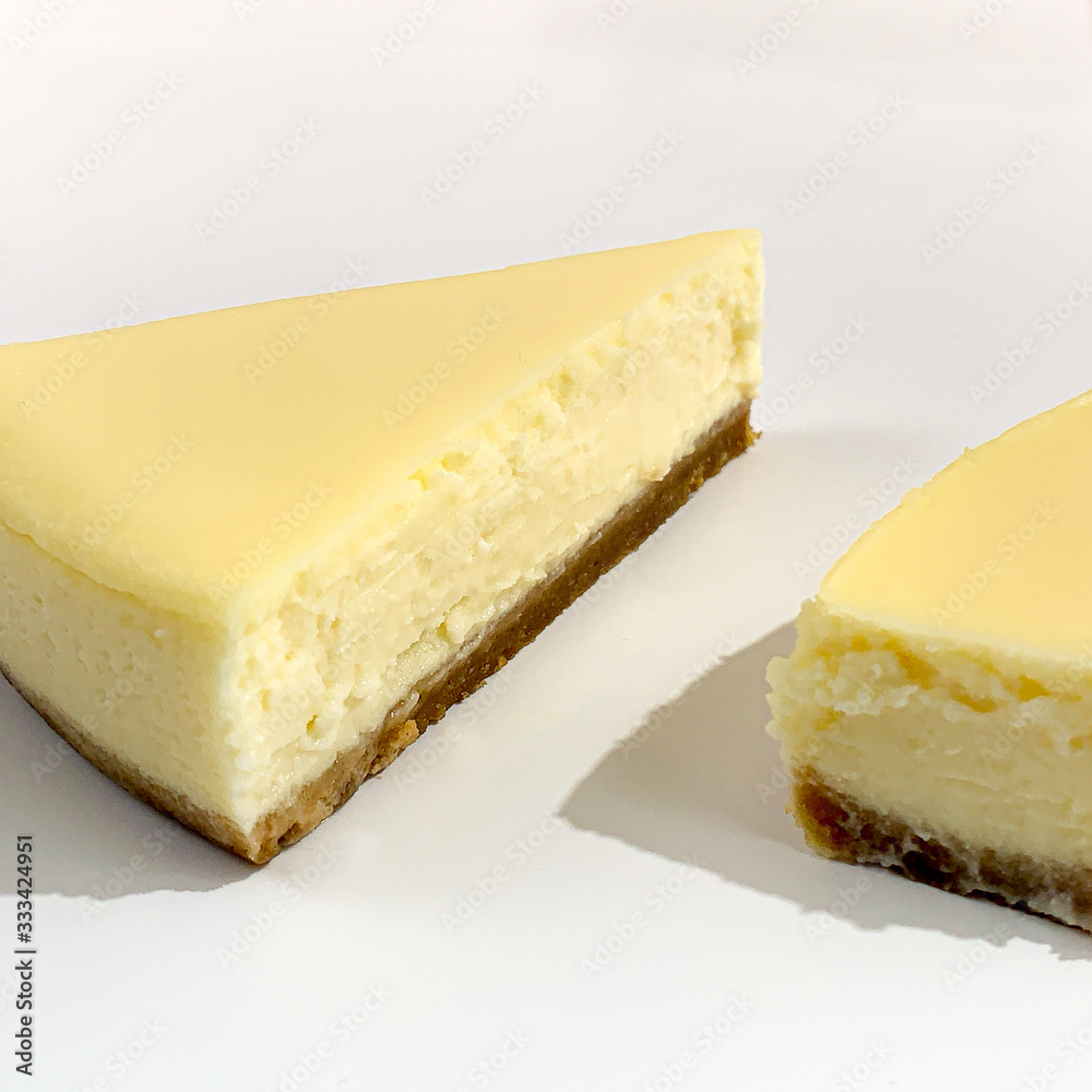 Bright pieces of cheesecake on white pink background Bright pieces of cheesecake on white pink background