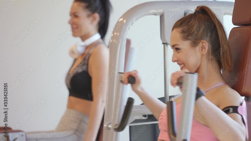 Young woman working out chest exercise on a machine in the gym Young woman working out chest exercise on a machine in the gym