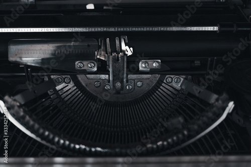 Old mechanical typewriter. Close-up of the mechanism. Toned dark image.
