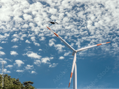 Wind turbine with beautiful clouds on the sky background.