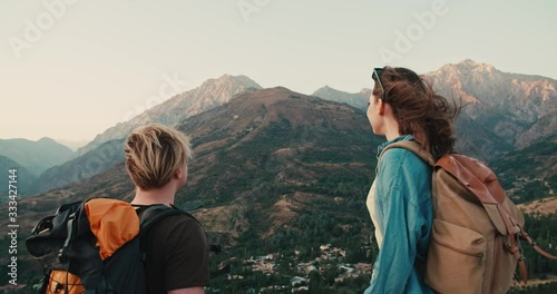 Young couple having an adventure, exploring beautiful mountains, hiking with backpacks, doing a fistbump - active lifestyle, freedom concept 4k footage photo