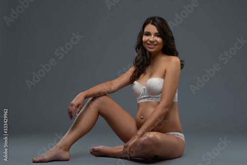Beautiful pregnant young woman in white underwear isolated on a gray background. Healthy pregnancy and happy motherhood © Yarkovoy