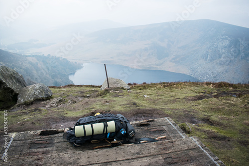 Mochila de senderismo en un paisaje con un lago, montañas y bosques en Irlanda photo