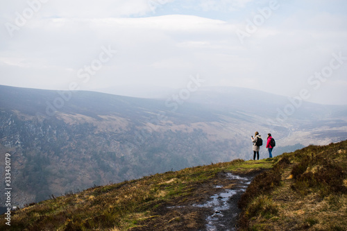 Dos personas contemplando un amplio paisaje en las monta  as de Irlanda