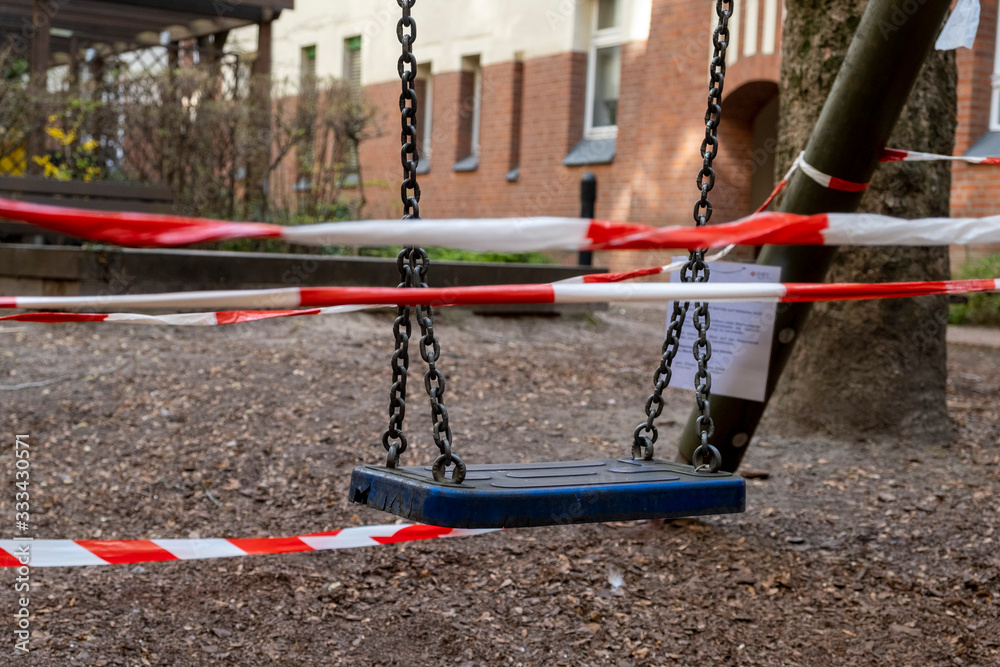Corona crisis - Children's playground cordoned off with a red and white barrier tape in the courtyard of a residential building in Berlin-Prenzlauer Berg. So the contact ban should be enforced.