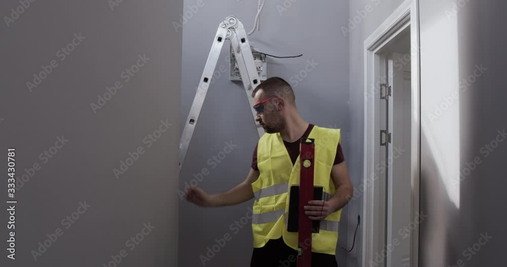 A man, a worker on the construction site. Inspector checks the quality of the works and makes notes in the notebook. A man, a worker on the construction site. Inspector checks the quality of the works and makes notes in the notebook.