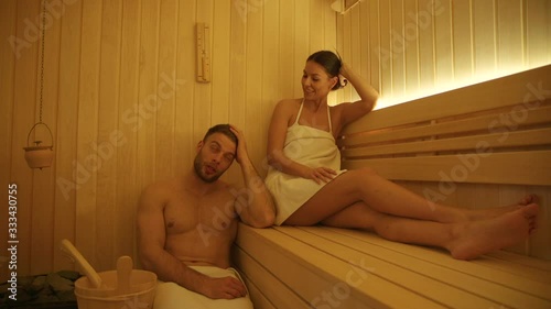 Handsome young couple relaxing in the sauna